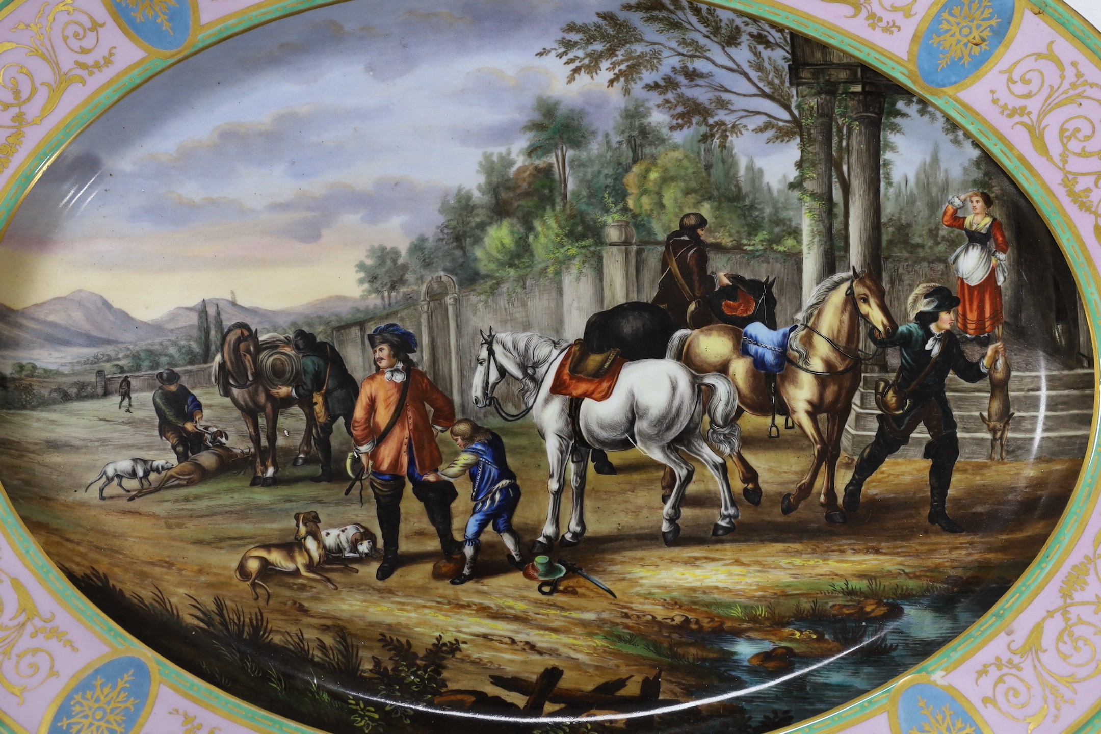 A large Vienna style porcelain oval dish, late 19th century, painted with huntsmen and horses in a landscape, 52cm long